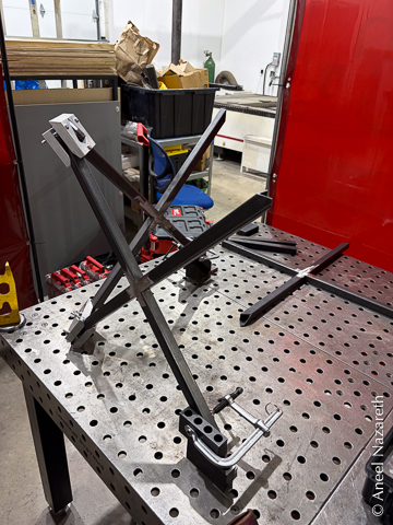 Two X shapes are fixtured to the table using conventional fixtures and the corners where they join are in the custom jigs